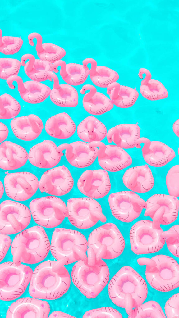 Whimsical Pink Flamingo Pool Floats on Turquoise Water Wallpaper