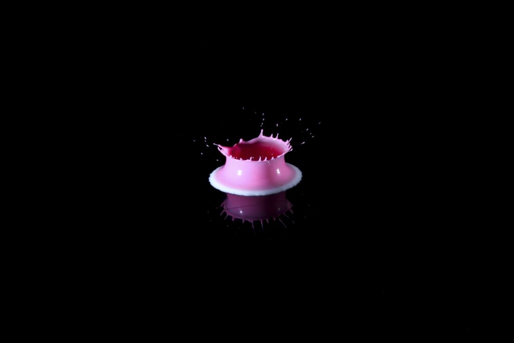 Vibrant Pink Paint Splash on Black: Stunning Fluid Dynamics Wallpaper