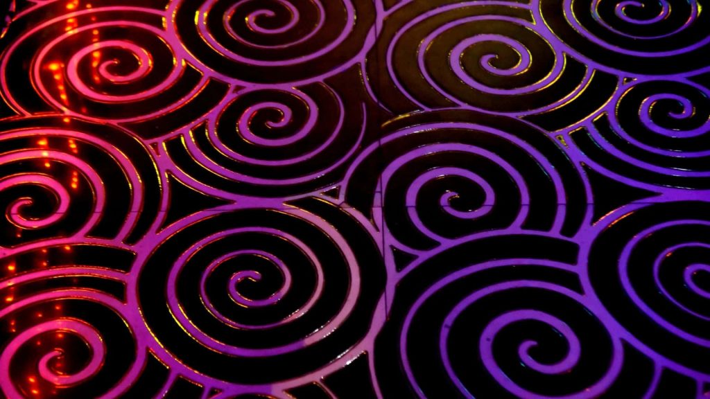 Vibrant pink purple spiral pattern background with glossy dark swirls neon glow abstract wallpaper