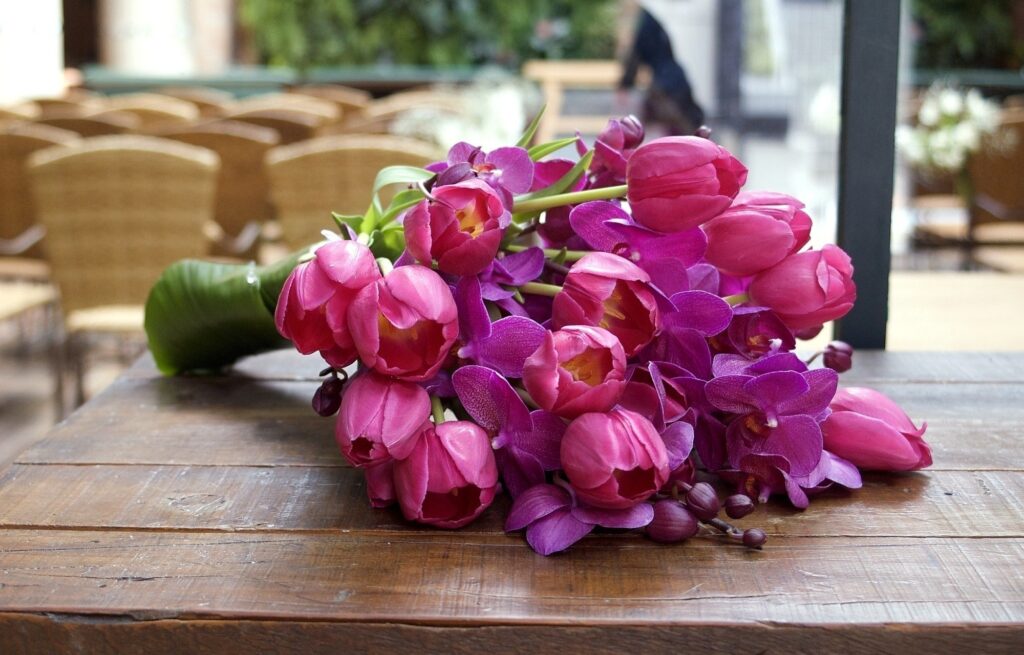 Vibrant Pink Tulips & Orchids Wallpaper on Rustic Wooden Table