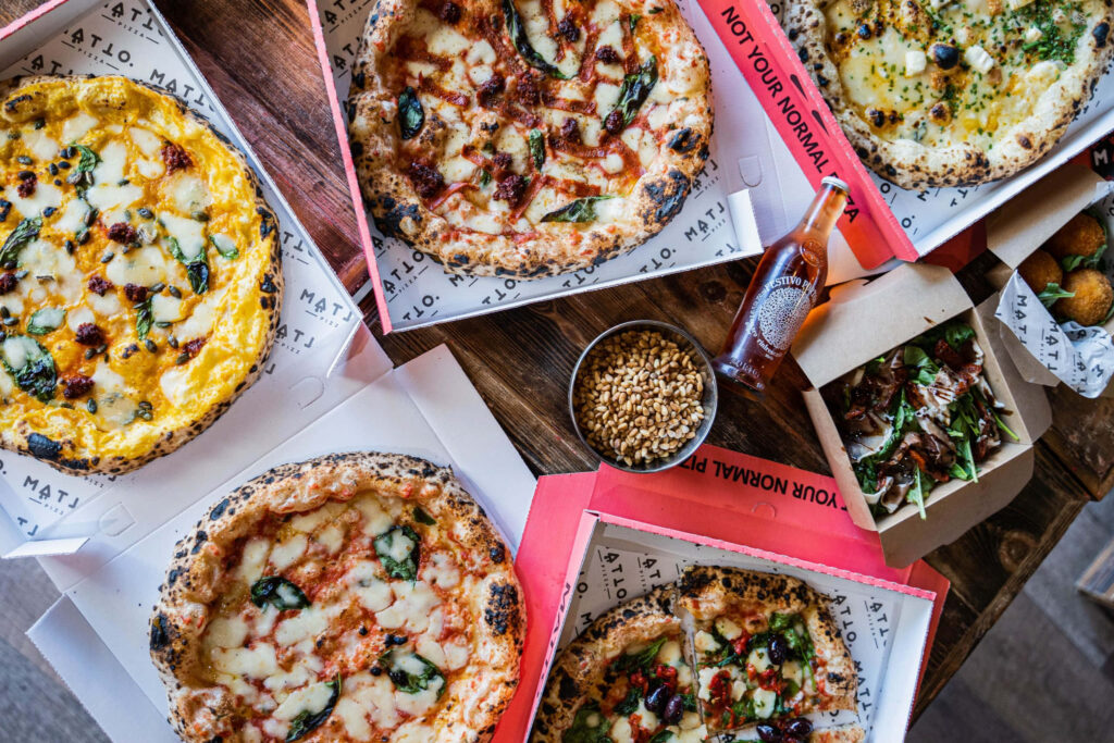 Vibrant Pizza Assortment with Sides - Perfect Meal Wallpaper