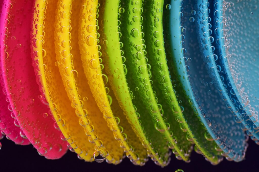 Colorful Plastic Spoons: Artistic Water-Drop Wallpaper Background
