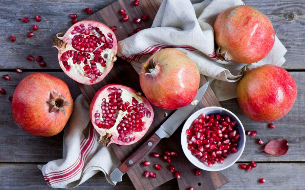 Vibrant Pomegranate Flat Lay Wallpaper with Juicy Red Seeds