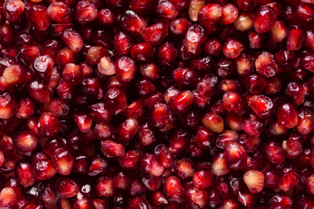 Vibrant Pomegranate Seeds Wallpaper: Glossy Red Texture Background
