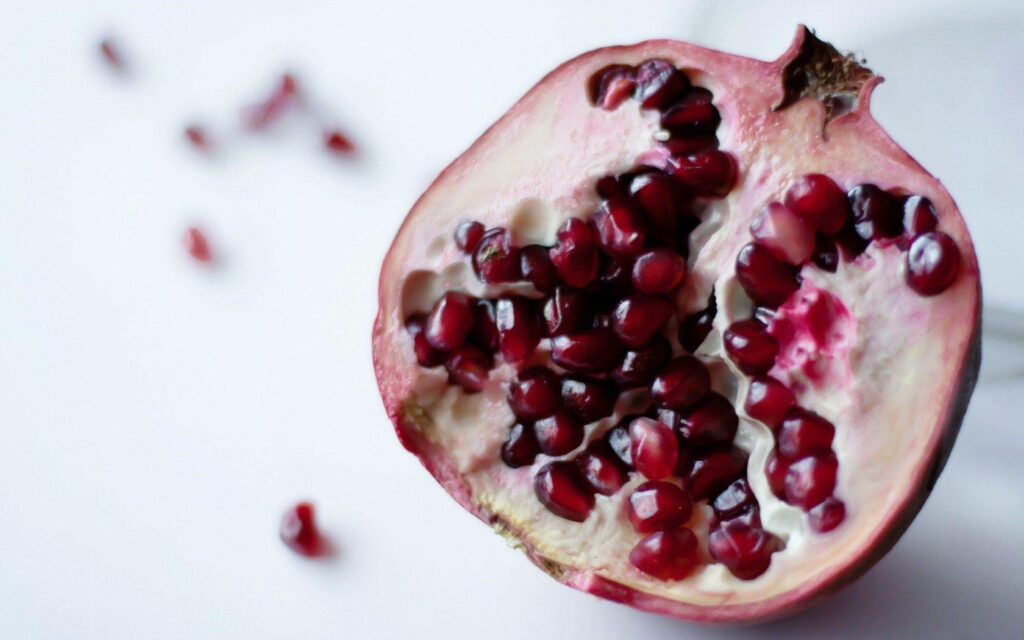 Vibrant Pomegranate Wallpaper: Intricate Red Seeds & Textured Rind