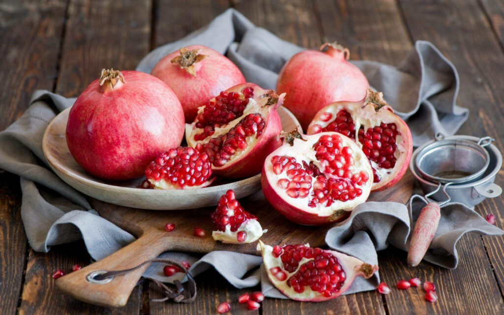 Fresh Pomegranate Wallpaper: Juicy Seeds on Rustic Table Background