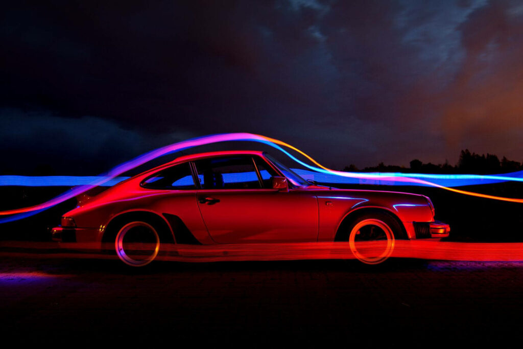 Vibrant Porsche 911 Wallpaper: Sleek Side Profile & Dynamic Light Trails