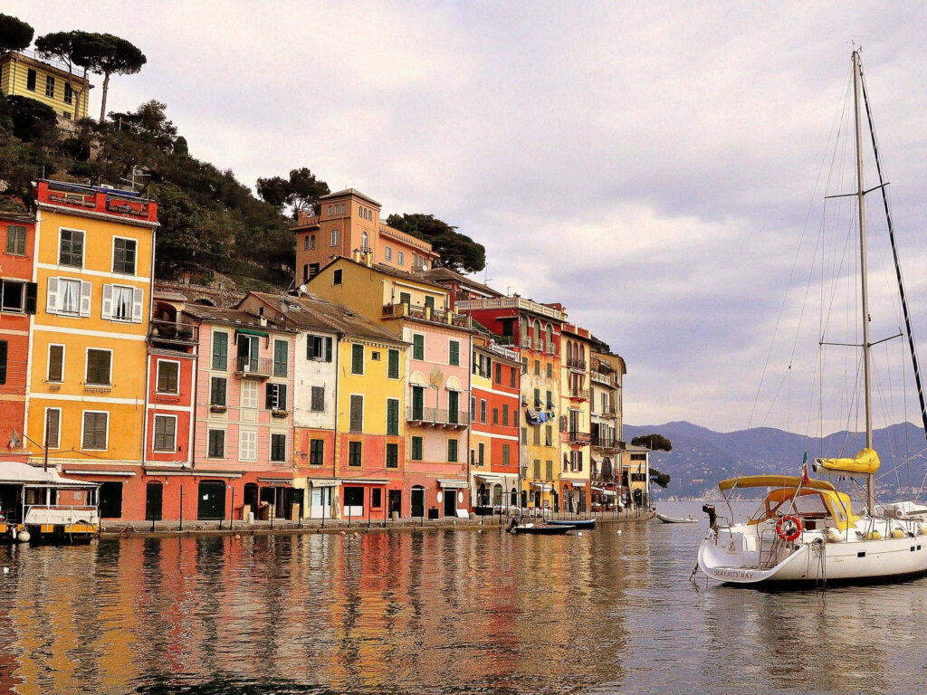 Vibrant Portofino Houses & Sailboat - Coastal Wallpaper Background