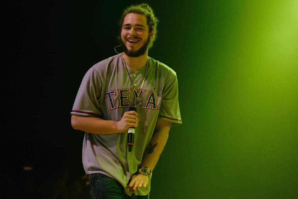 Vibrant Wallpaper: Post Malone Live with Energetic Stage Presence