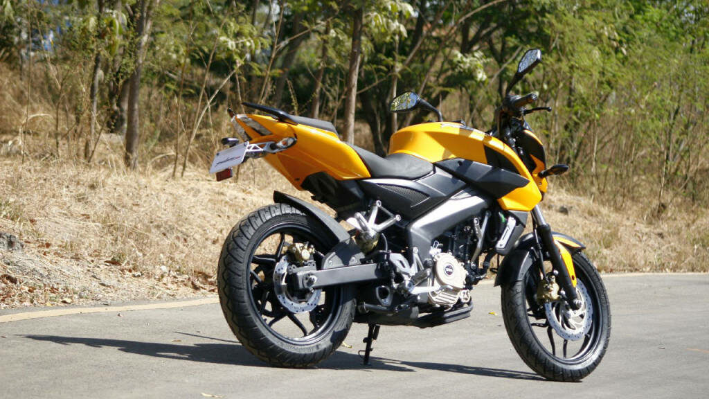 Vibrant Yellow Pulsar RS200 Motorcycle Wallpaper in Scenic Setting
