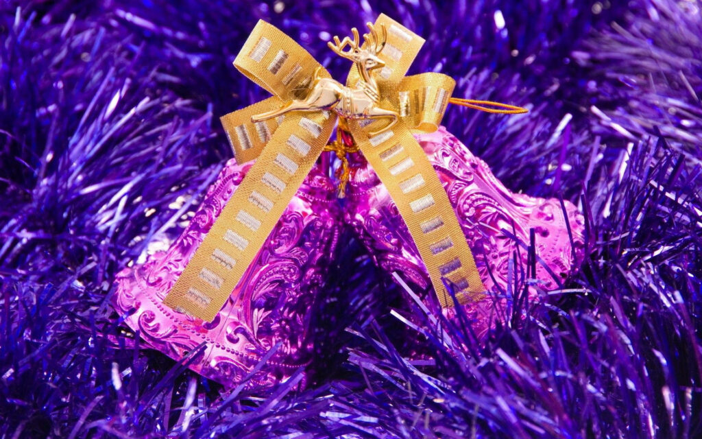Vibrant Purple Festive Bells with Gold Ribbon & Tinsel Background Wallpaper