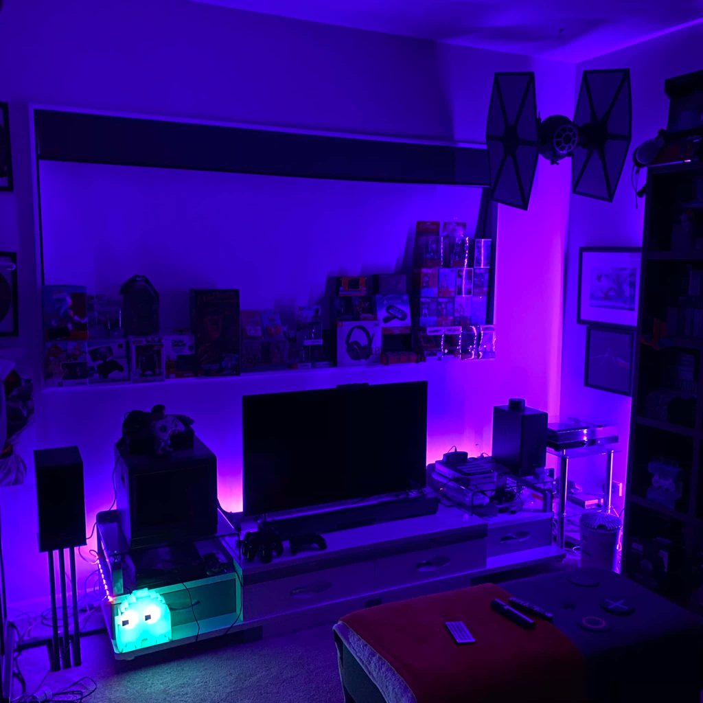 Gaming room with purple neon lights Pac-Man ghost lamp and Star Wars TIE Fighter decor Wallpaper