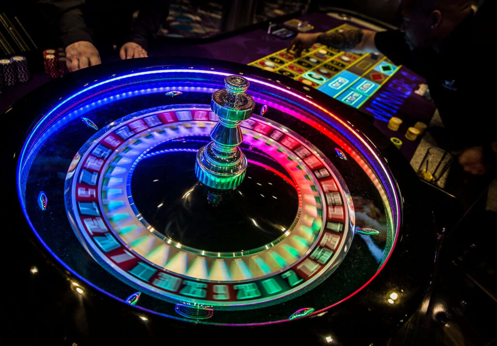 Vibrant roulette wheel with RGB lights reflecting on glossy casino table vibrant gaming wallpaper