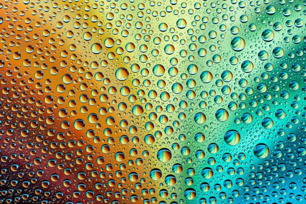 Vibrant 6000x4000 Water Droplets on Rainbow Gradient Background Wallpaper