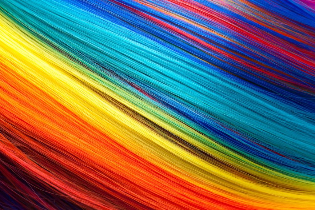 Vibrant rainbow macro close-up of silky multicolored hair strands bright diagonal stripes wallpaper