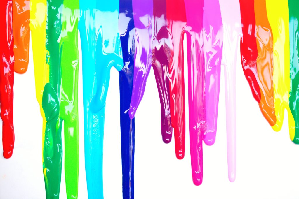 Vibrant rainbow paint drips cascading on white background colorful glossy liquid wallpaper