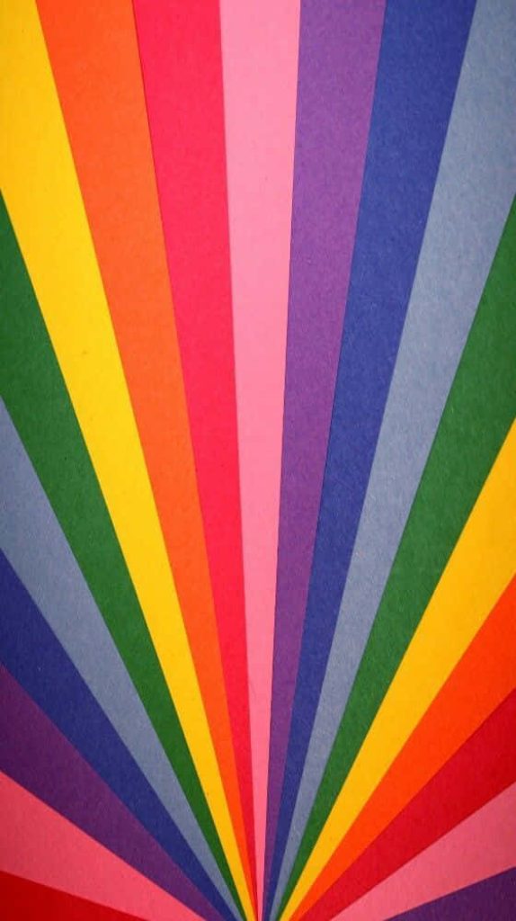 Vibrant rainbow sunburst wallpaper with colorful wedge stripes in a modern flat design background