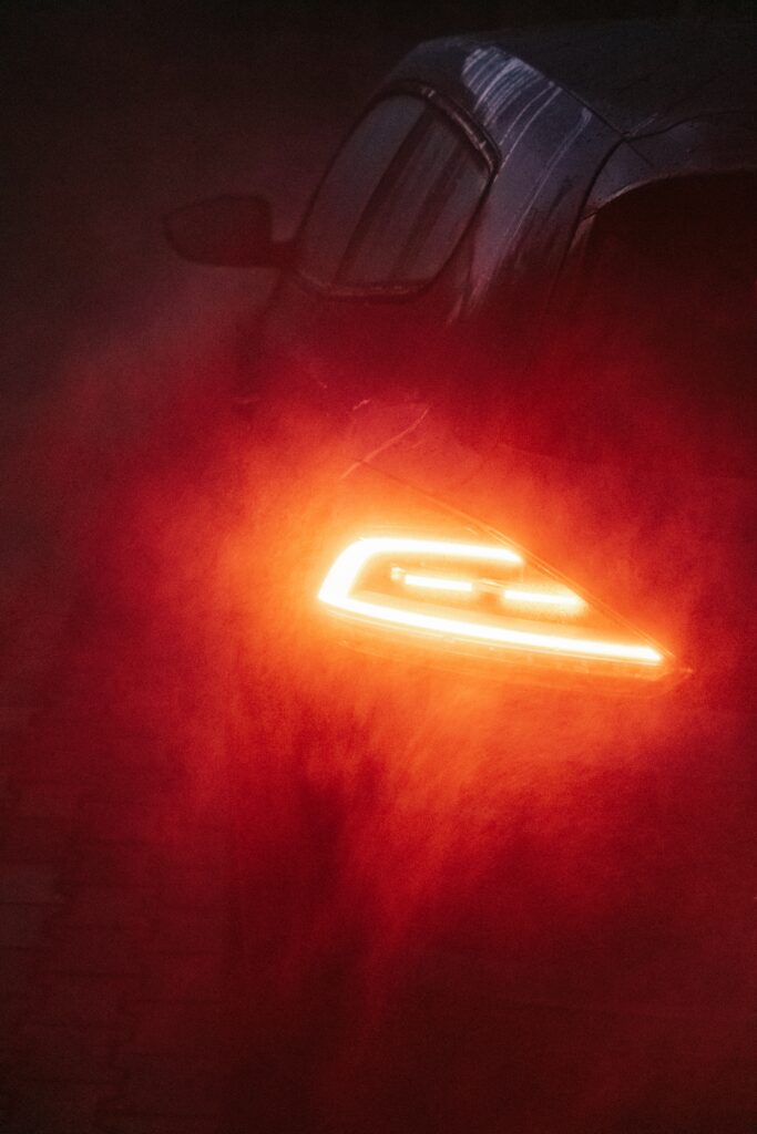 Striking Rainy Car Scene with Vibrant Red Backlight Wallpaper