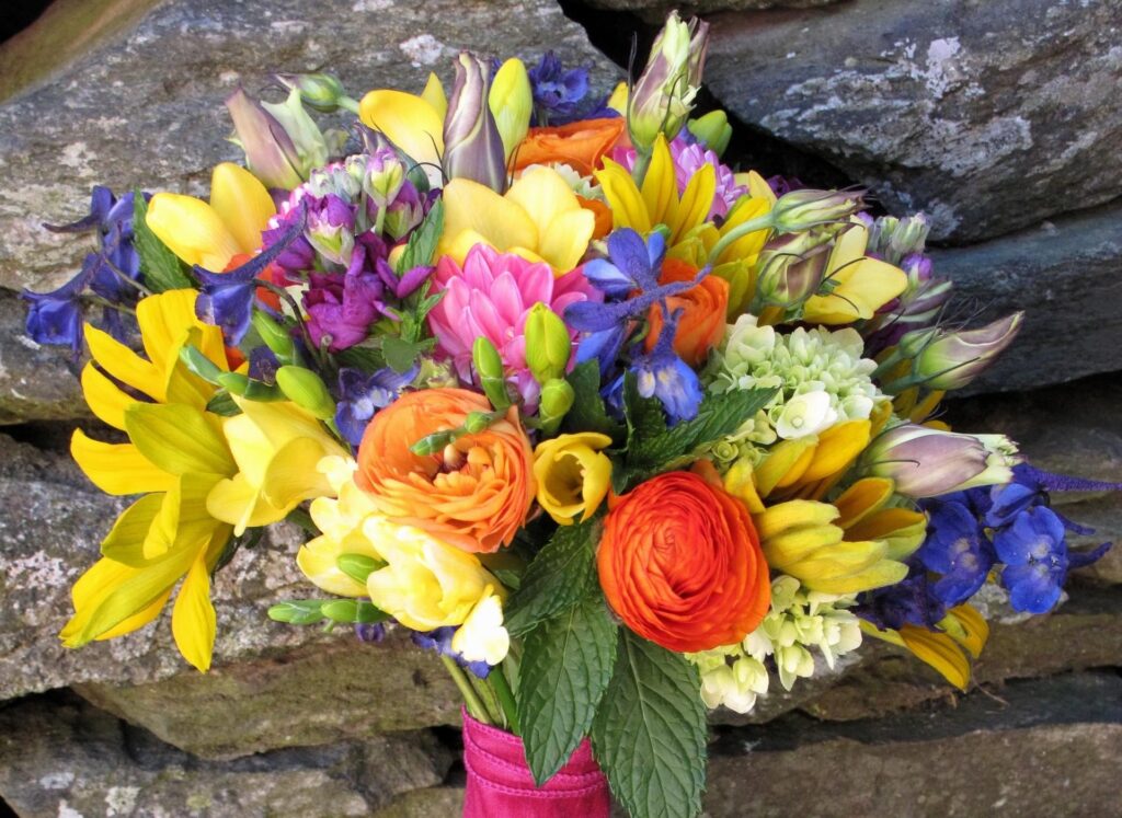 Vibrant Ranunculus Bouquet Wallpaper: Colorful Floral Stone Background