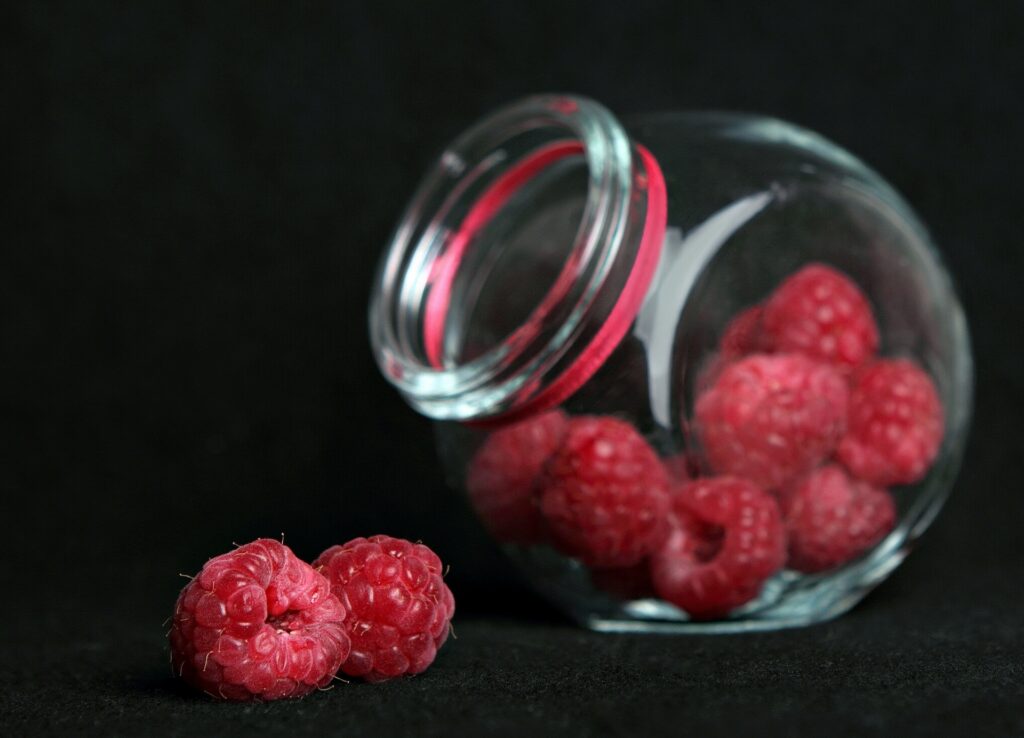 Vibrant Raspberry Wallpaper: Close-Up of Fresh Berries in Glass Jar