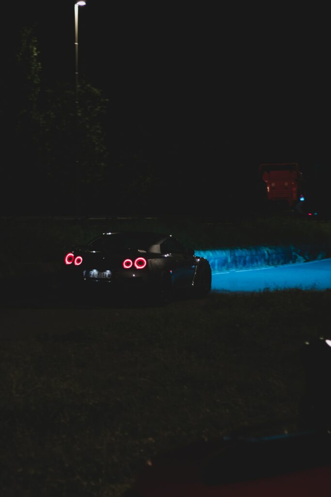 Rear View Sleek Car Wallpaper: Vibrant Headlights in Night Atmosphere