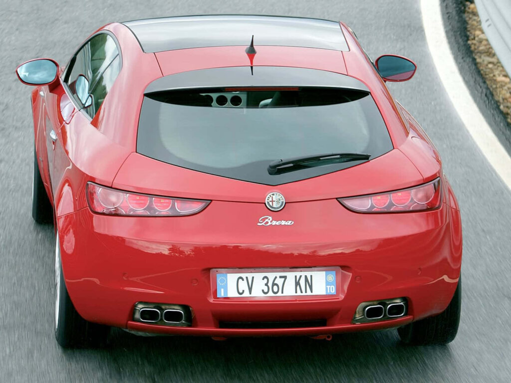Red Alfa Romeo Brera driving on winding road showing sporty rear design and stylish curves Wallpaper