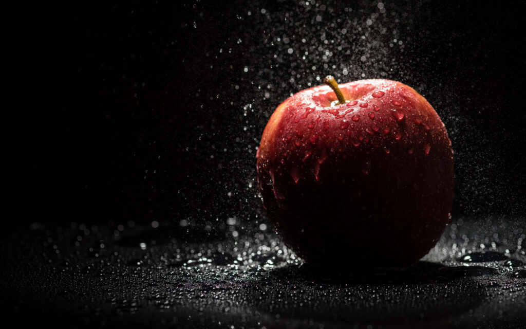Vibrant Red Apple 4K Wallpaper with Water Droplets & Dark Background