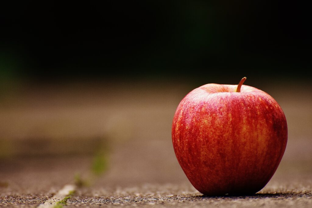 Vibrant Red Apple on Rustic Surface - Natural Wallpaper Background