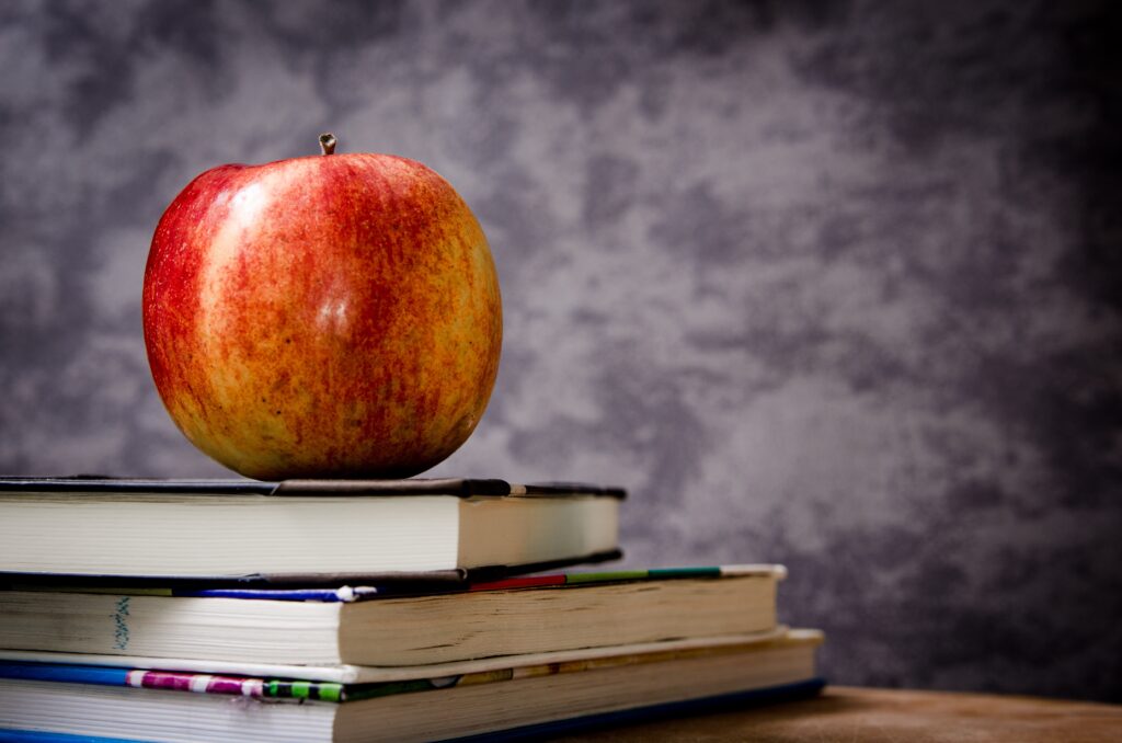 Vibrant Red Apple on Books - Artistic Gray Wallpaper Background