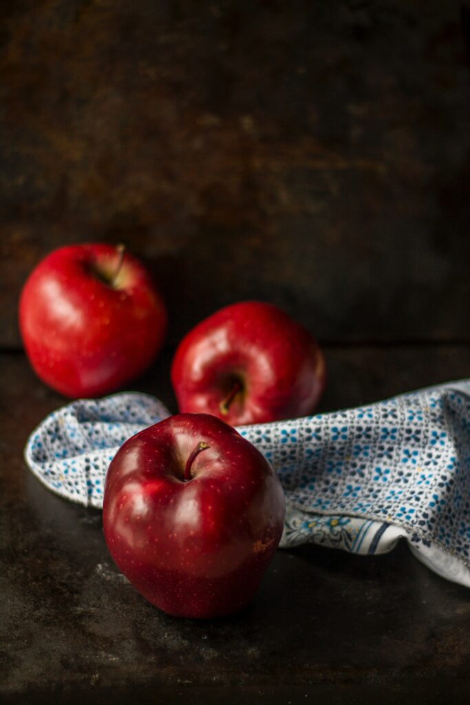 Vibrant Red Apples Still Life Wallpaper on Dark Textured Surface