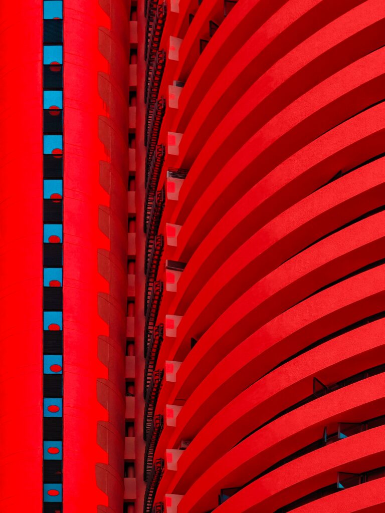Vibrant Red Architectural Facade Wallpaper with Blue Highlights