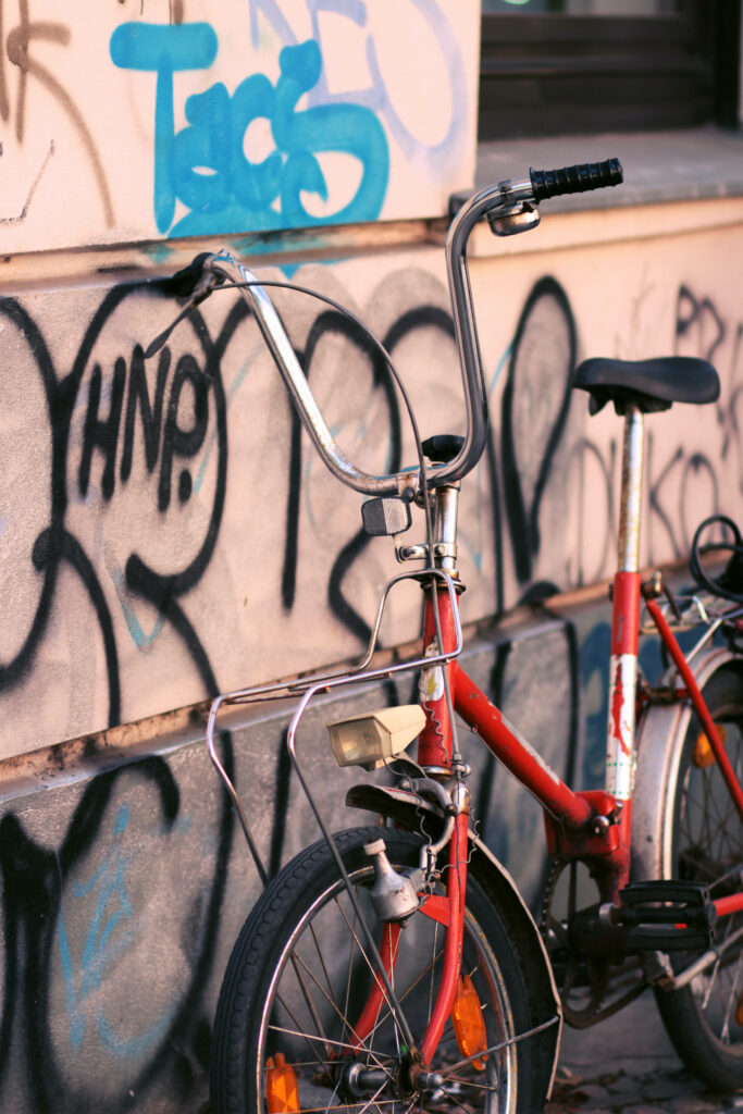 Vibrant red bike parked by colorful graffiti wall urban street art background wallpaper