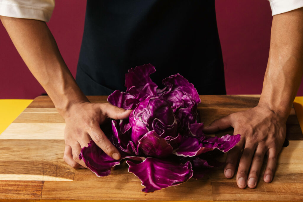 Vibrant Close-Up of Fresh Red Cabbage on Wooden Surface Wallpaper