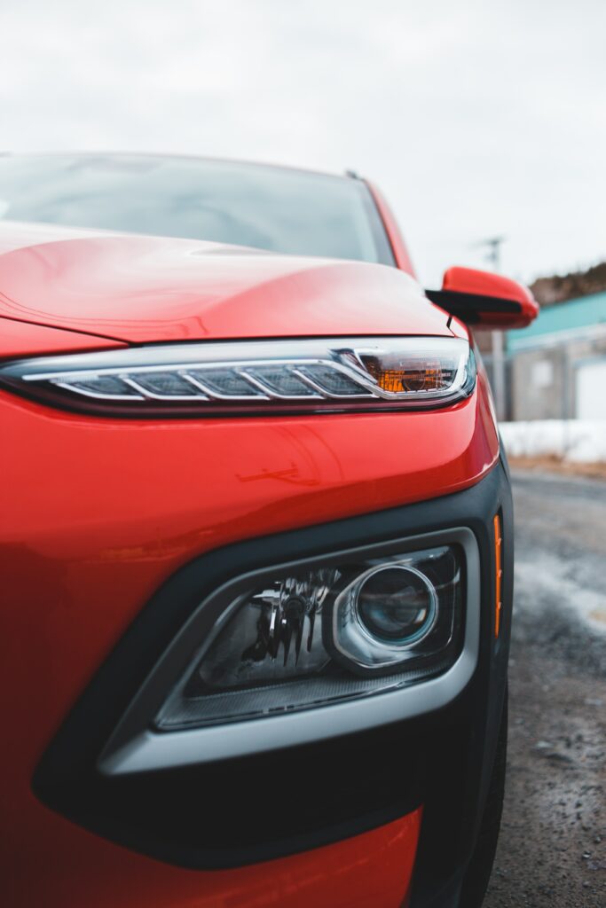 Stunning Red Car Wallpaper: Sleek Design & Modern Headlight Close-Up