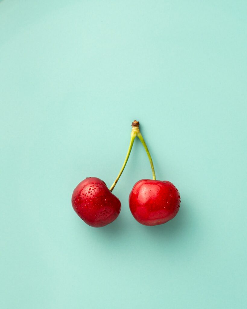 Vibrant Red Cherries Wallpaper - Minimalist Turquoise Background