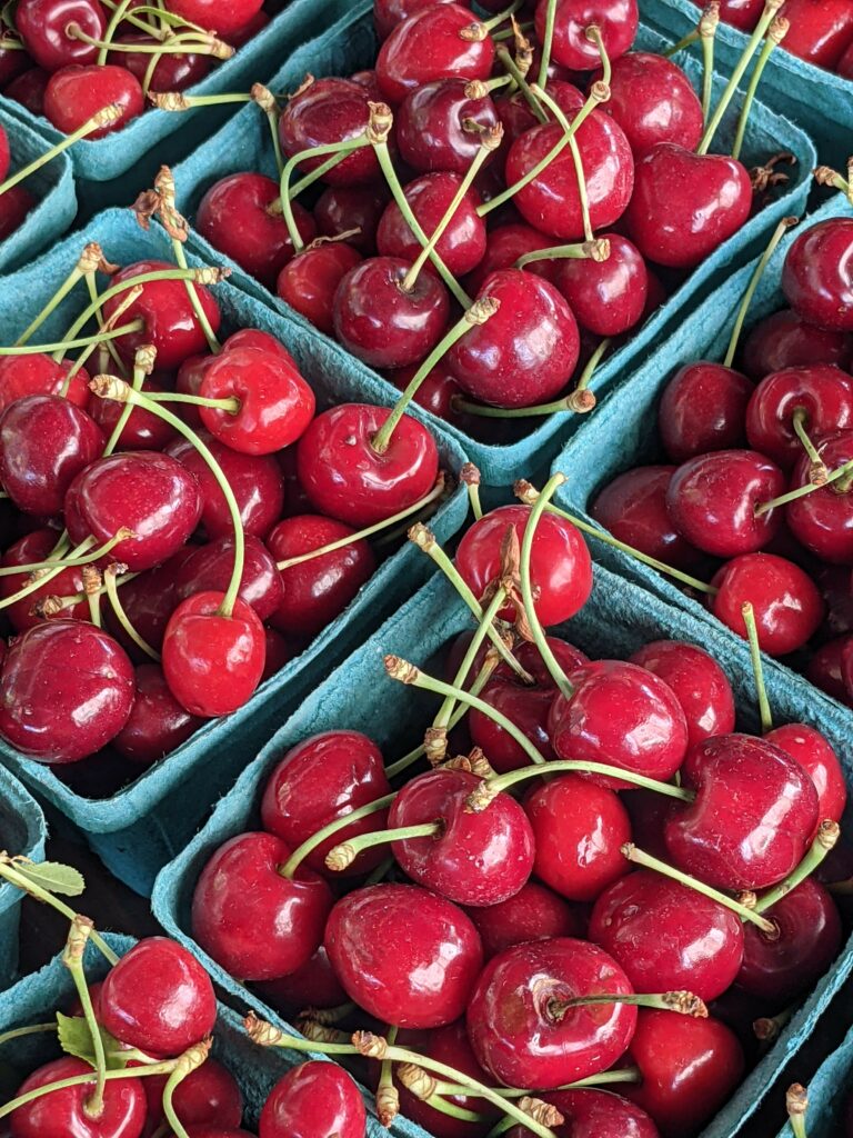Vibrant Red Cherries in Blue Containers - Fresh Wallpaper Background