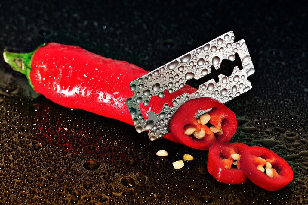 Vibrant Chilli Pepper Wallpaper with Razor Blade & Water Droplets