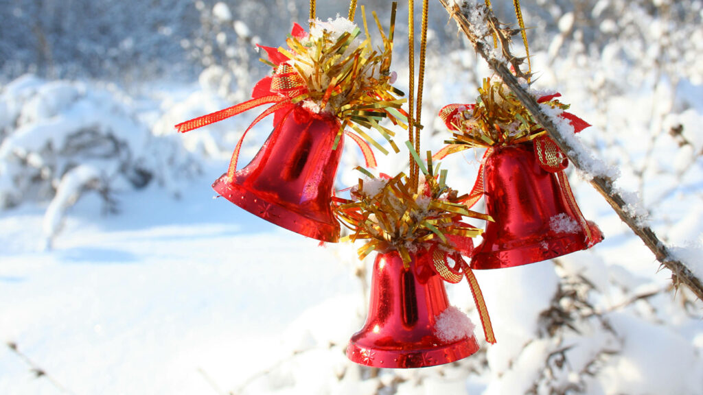 Festive Red Christmas Bells with Gold Ribbons on a Snowy Background Wallpaper