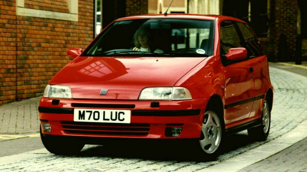 Vibrant Red Fiat Punto Wallpaper: Iconic Compact Design in Urban Setting