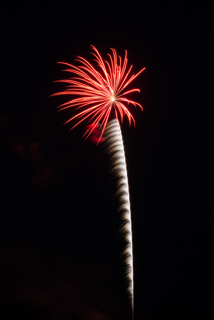 Vibrant Red Firework Wallpaper Against Black Night Sky Background