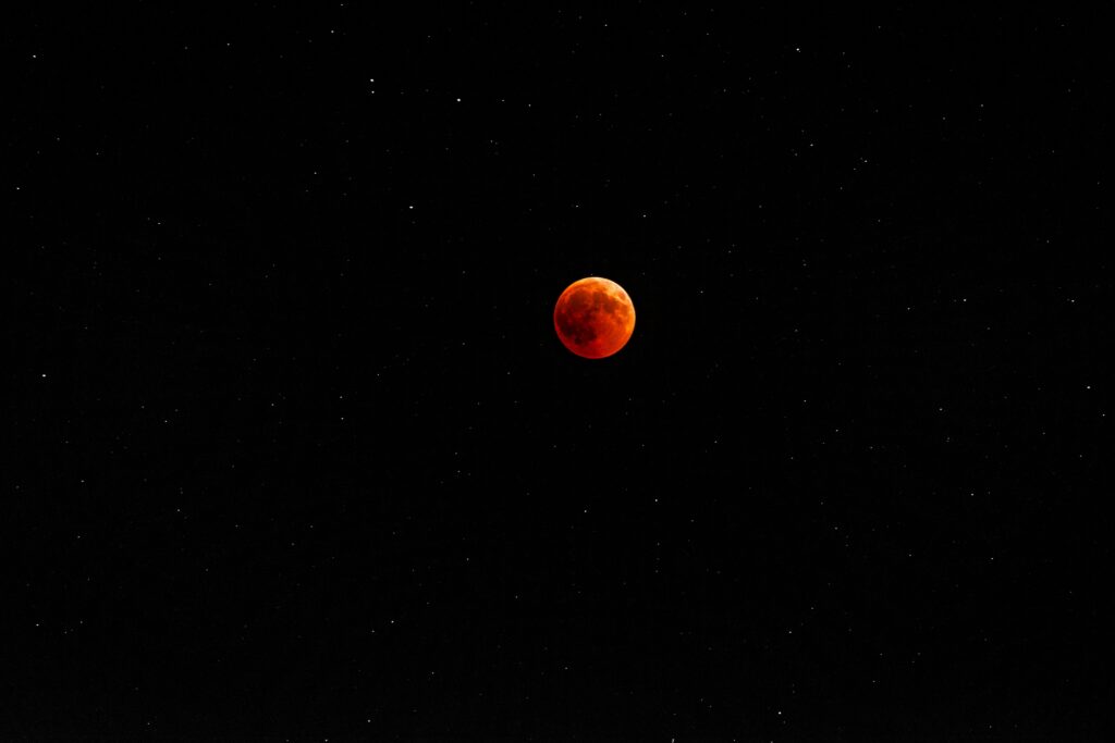 Vibrant Red Full Moon Wallpaper Against Starry Night Sky