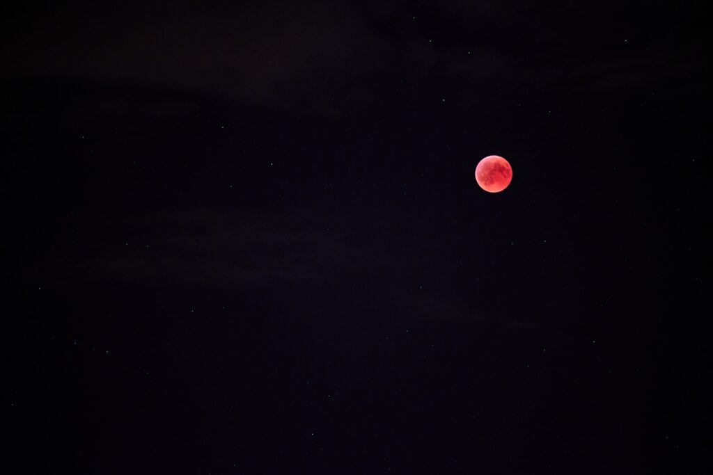 Vibrant Red Full Moon Wallpaper Against Starry Night Sky