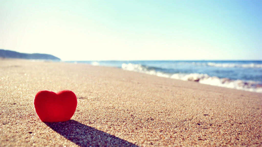 Vibrant Red Heart on Sandy Beach - Serene Romantic Wallpaper