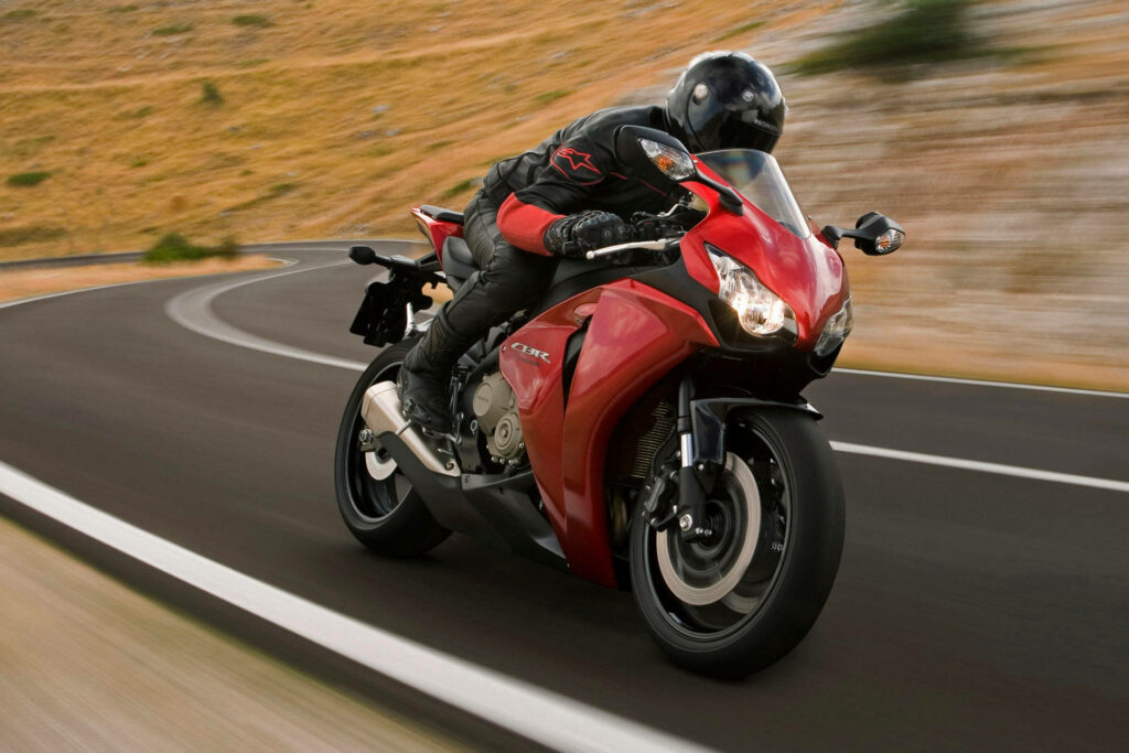 Vibrant Red Honda Fireblade Wallpaper: Adrenaline on Winding Roads