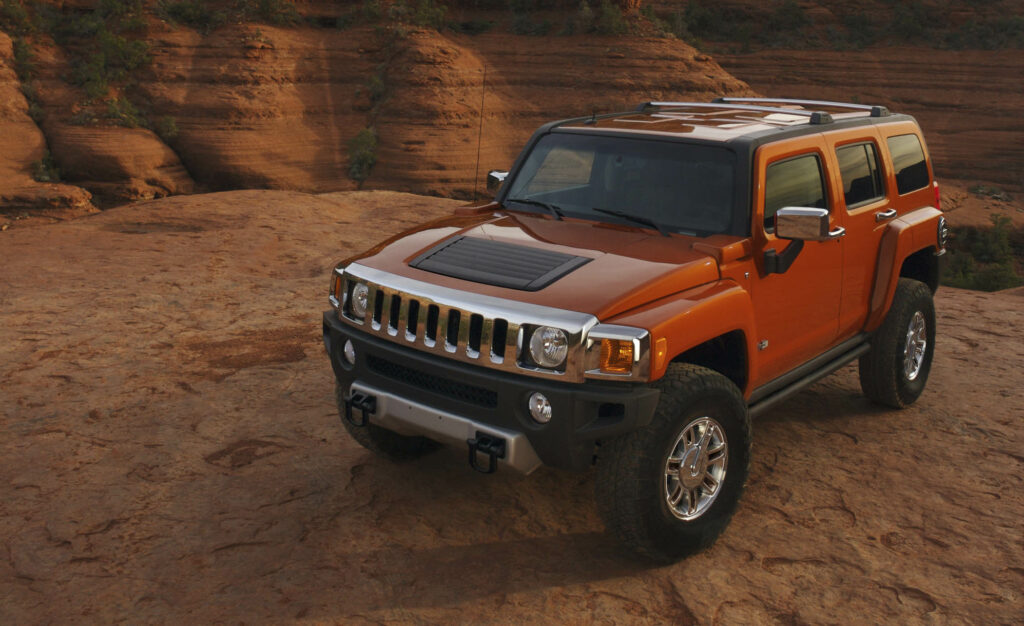 Vibrant Red Hummer H3: Side View in Rugged Natural Landscape Wallpaper
