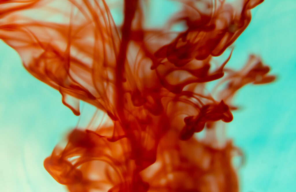 Vibrant Red Ink Swirls on Turquoise: Abstract Fluid Wallpaper
