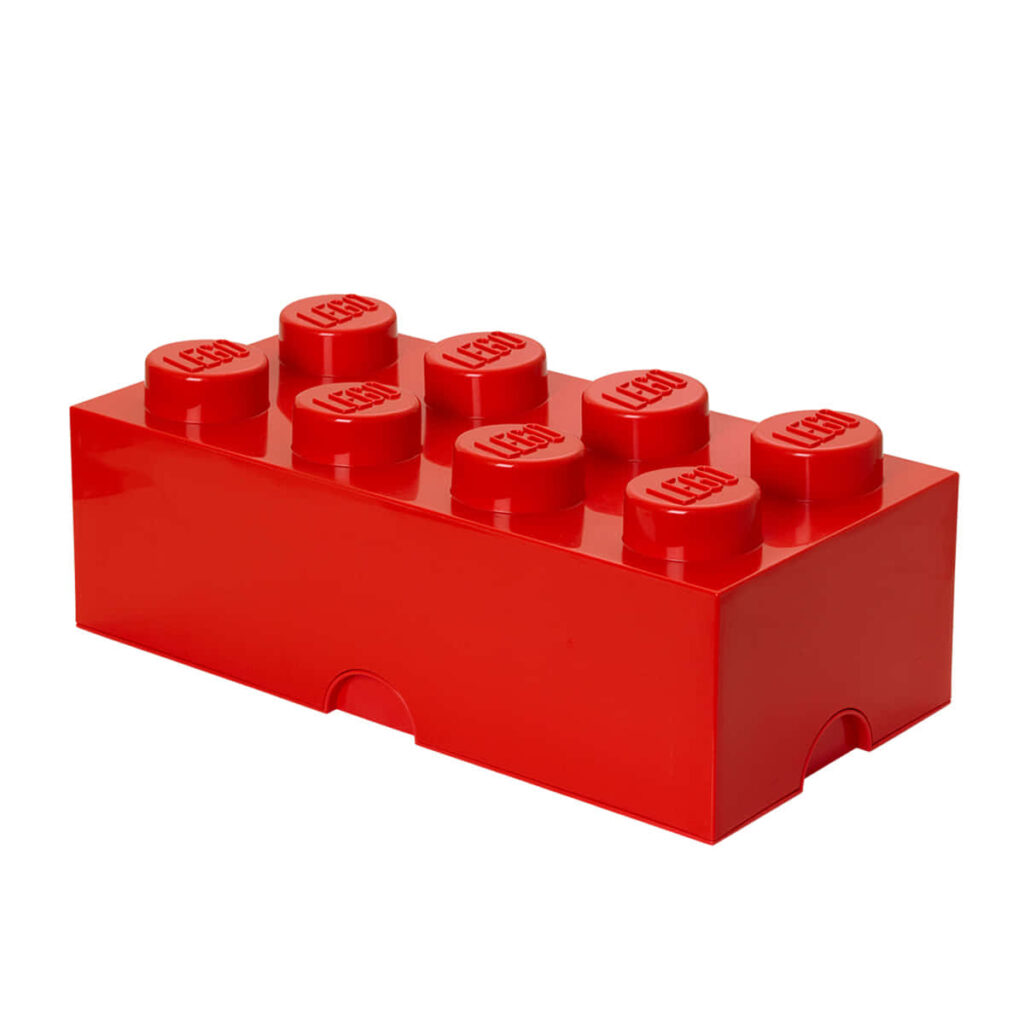 Vibrant red Lego brick with embossed logo on studs against clean white background wallpaper