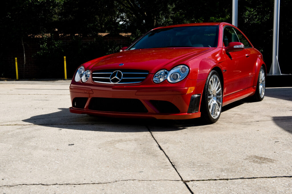 Vibrant Red Mercedes: Sleek Design in Sunlit Parking Space Wallpaper