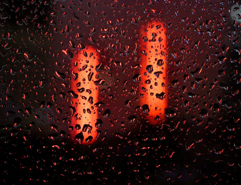 “Vibrant Macro Wallpaper: Glowing Red Neon Lights with Water Droplets”