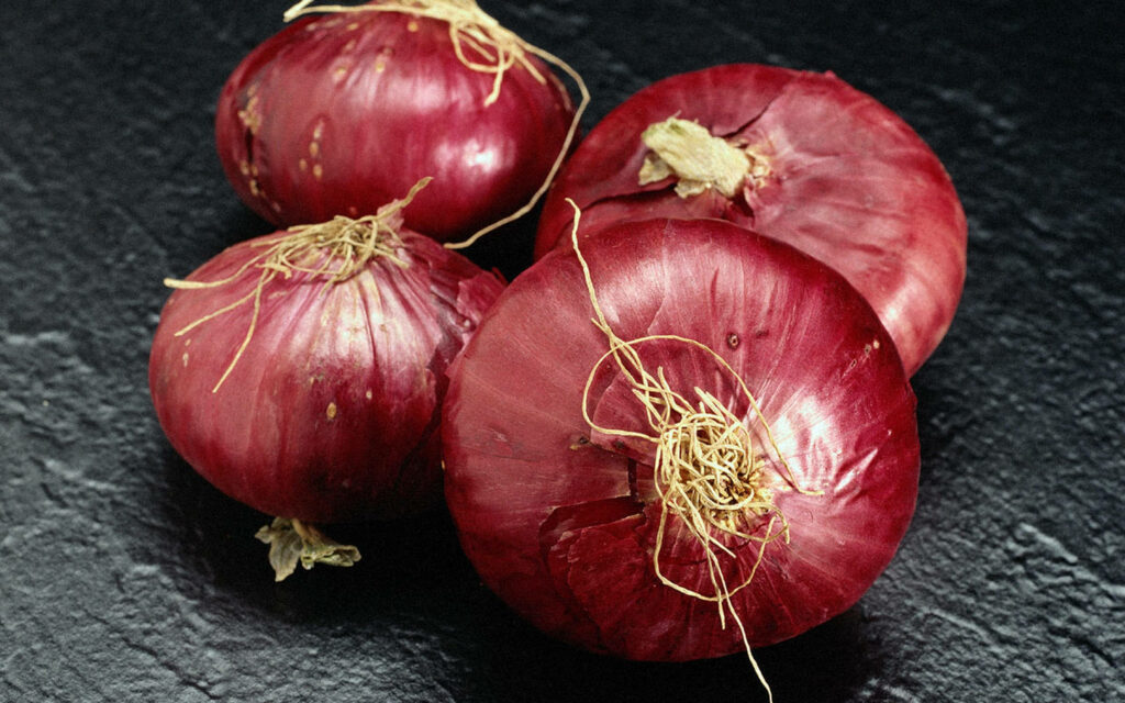 Vibrant Red Onion Wallpaper: Textured Dark Background Close-Up